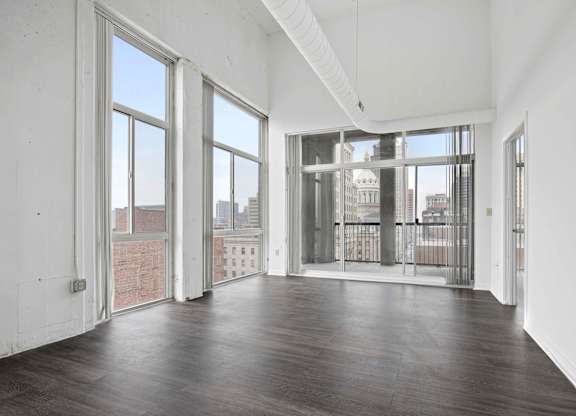 A large empty room with wooden floors and white walls.