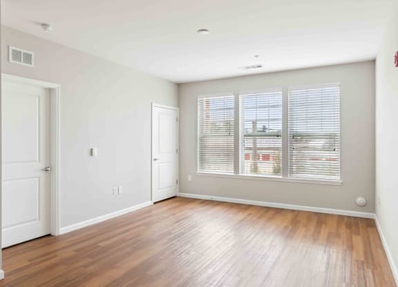 a bedroom with hardwood floors and a large window at West 130, New York , 11552