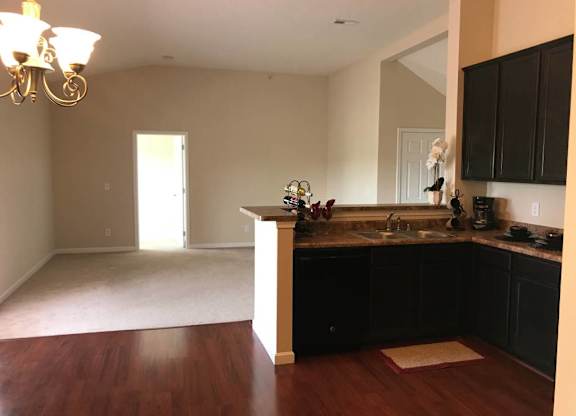 A kitchen with dark wood cabinets and a light-colored floor at The Legends at Steeplechase Apartments, Richwood