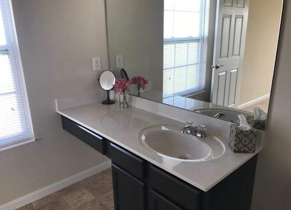 A bathroom with a white sink and a mirror at The Legends at Steeplechase Apartments, Richwood, KY, 41094