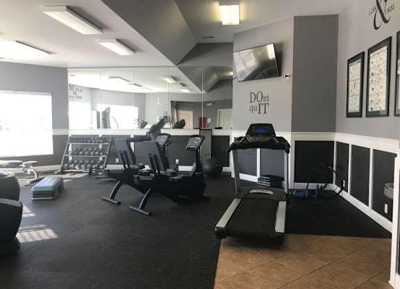 A gym with treadmills, weights, and exercise equipment at The Legends at Steeplechase Apartments, Richwood, KY