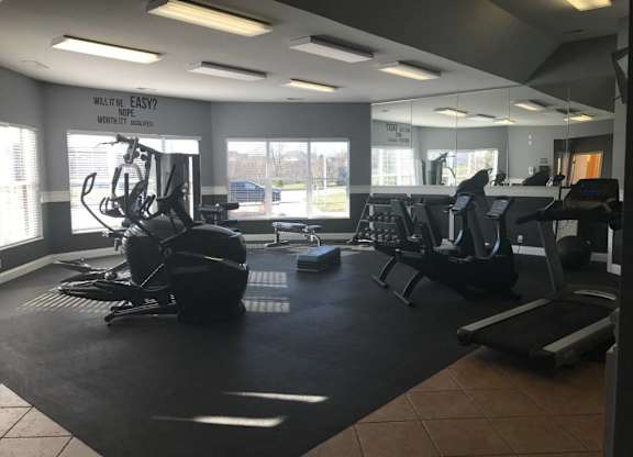 A gym with a variety of equipment including treadmills, weights, and exercise machines. at The Legends at Steeplechase Apartments, Richwood, KY, 41094