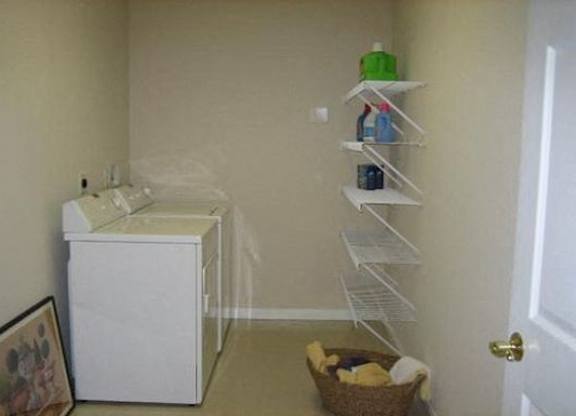 A white cabinet with a basket underneath it and a white door. at The Legends at Steeplechase Apartments, Kentucky, 41094