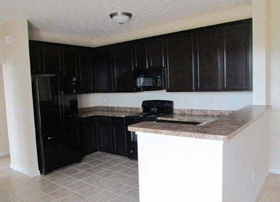 A kitchen with black cabinets and a granite countertop at The Legends at Steeplechase Apartments, Richwood, KY, 41094