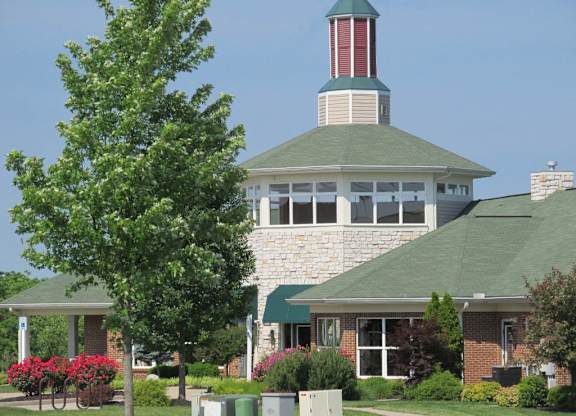 A building with a green roof and a red and white tower at The Legends at Steeplechase Apartments, Richwood, Kentucky