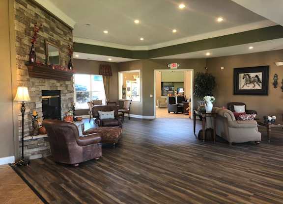 A living room with a fireplace and a chair at The Legends at Steeplechase Apartments, Richwood, 41094