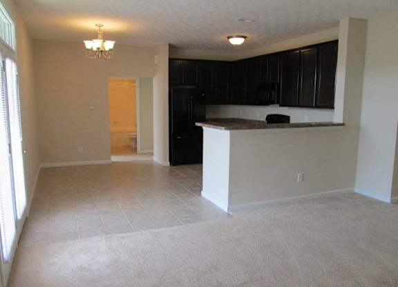 A kitchen area with black cabinets and a brown countertop at The Legends at Steeplechase Apartments, Richwood, KY