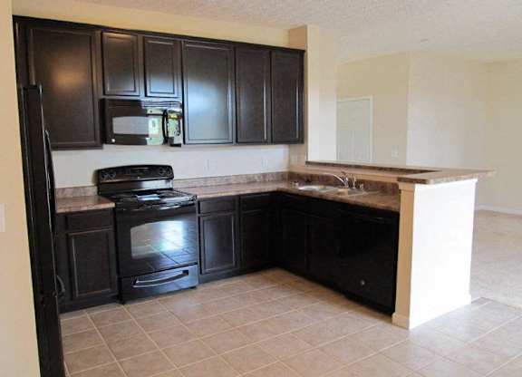 A kitchen with black cabinets and a black stove top oven at The Legends at Steeplechase Apartments, Richwood, KY, 41094