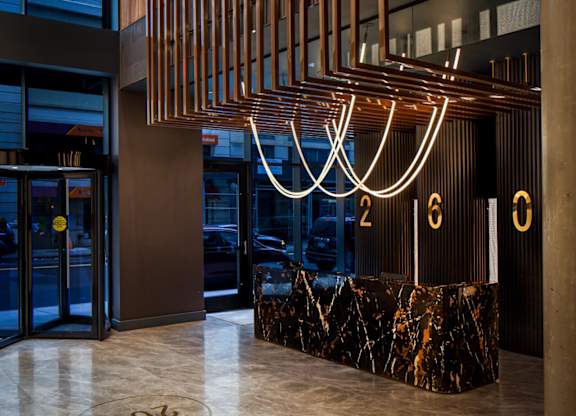 the lobby of the building has a marble reception desk and a large number of lights