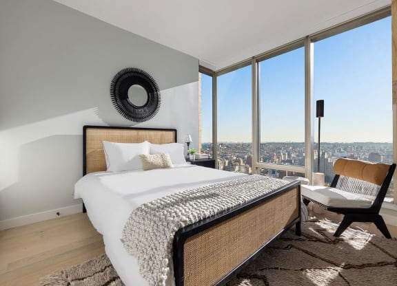 a bedroom with a bed and a view of the city at The Paxton, Brooklyn, 11201