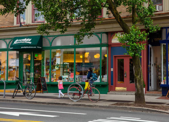 a man walking down the street with a bike at The Paxton, Brooklyn, New York