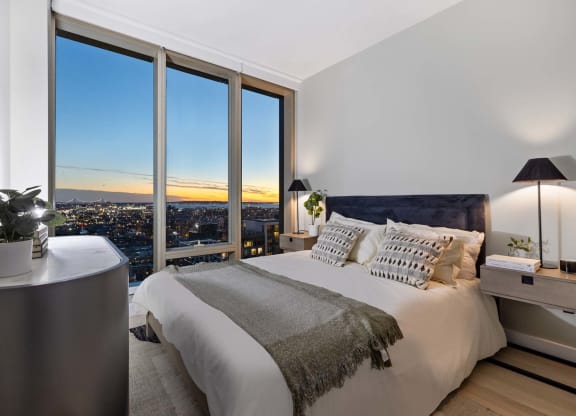 a bedroom with a bed and a view of the city at The Paxton, Brooklyn