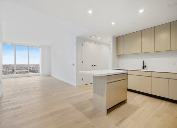 a living room with a kitchen and a window at The Paxton, Brooklyn, New York
