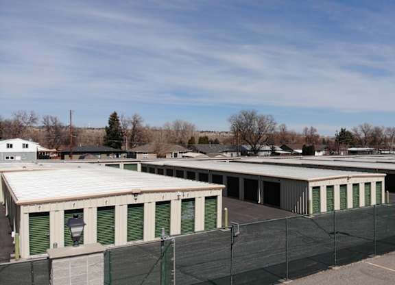 A parking lot with a building and a fence.