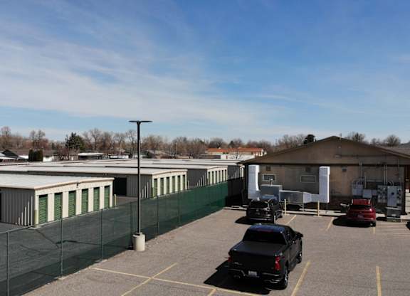 A parking lot with cars and a building in the background.
