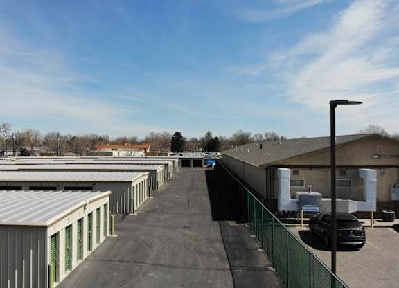A parking lot with a building and a fence.
