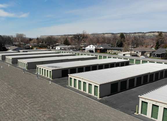 A parking lot with a few buildings in the background.