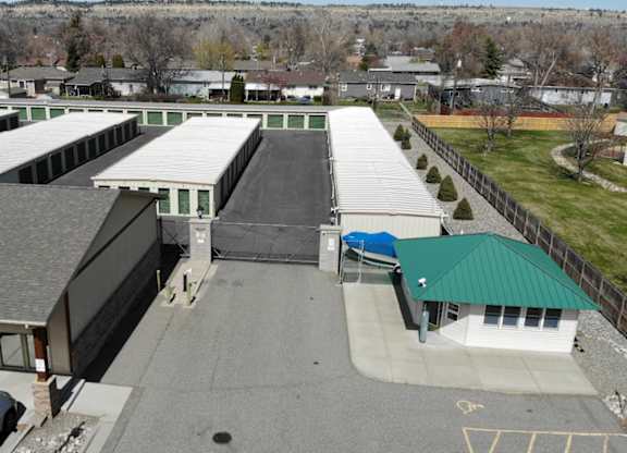 A parking lot with cars and a building with a green roof.