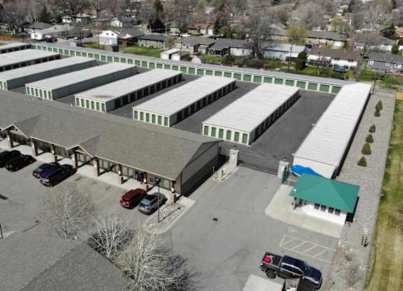 A parking lot with cars and a building with a green roof.