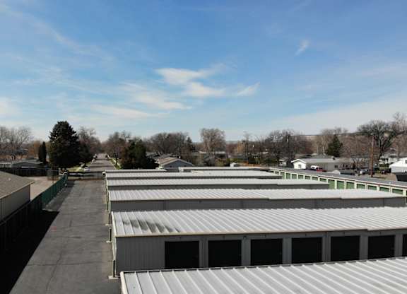 A large storage facility with multiple units and green doors.