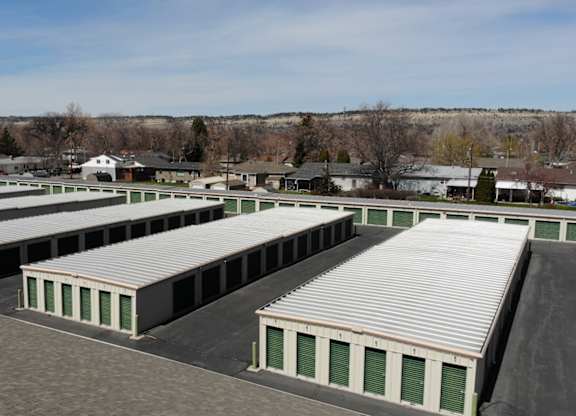 A large storage facility with multiple units and green doors.