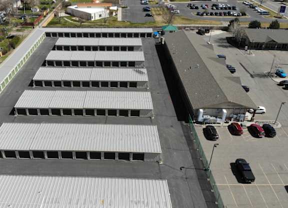 A large storage facility with multiple units and green doors.