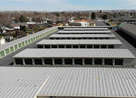 A large storage facility with multiple units and green doors.