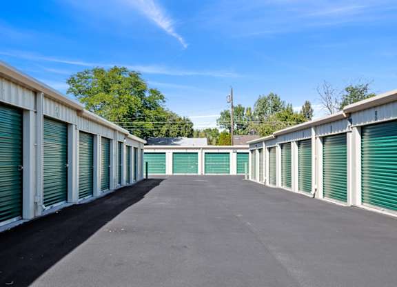 A long row of storage units with green doors.
