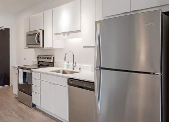 a kitchen with stainless steel appliances and white cabinets