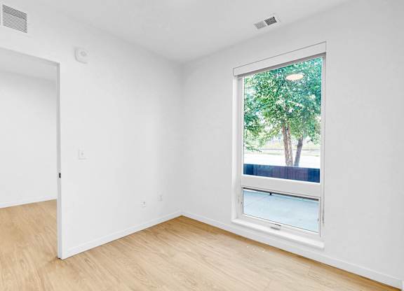 A room with a window showing a tree outside.