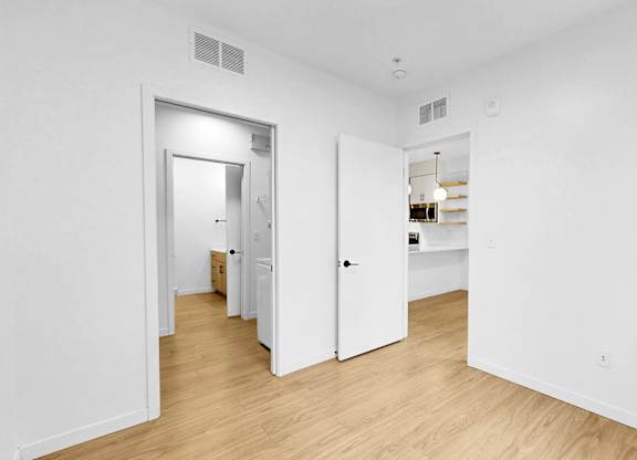A white room with a doorway leading to another room.