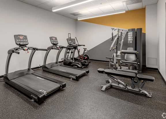 a gym with cardio equipment and weights in a building
