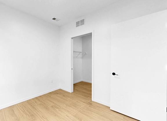 A white room with a wooden floor and a door.