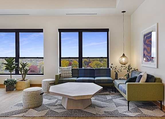 A living room with a couch, a table, and a large window.