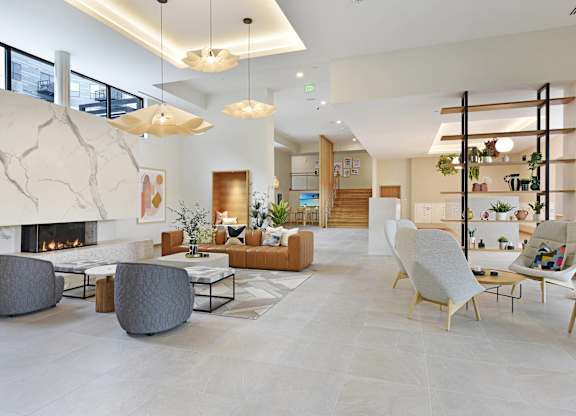 A modern living room with a fireplace and a variety of seating options.