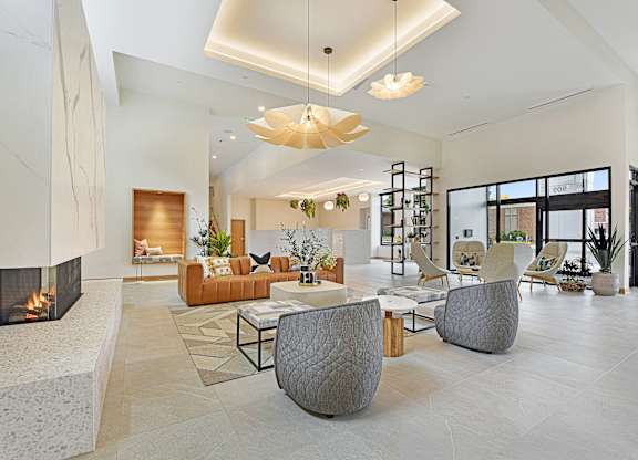 A modern living room with a fireplace and a large grey chair.