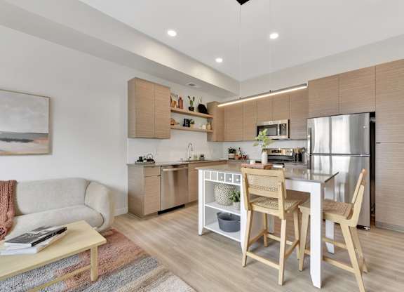 A modern kitchen with wooden chairs and a dining table.