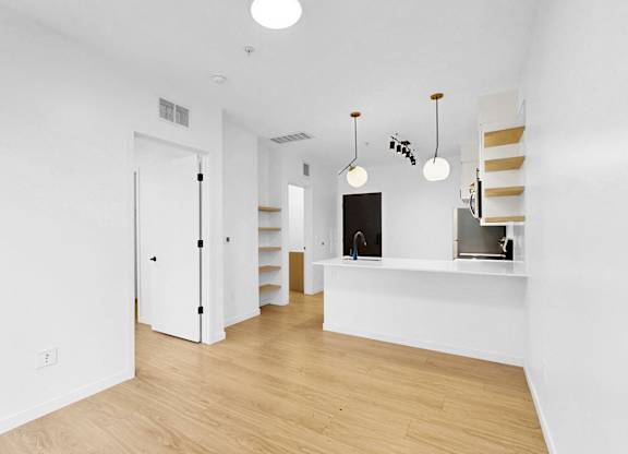 A white room with a wooden floor and a white door.