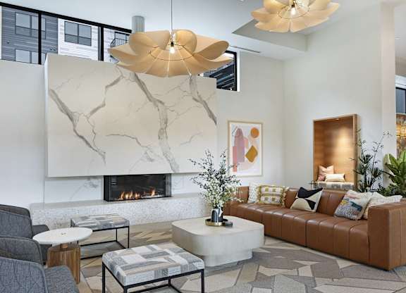A modern living room with a fireplace and a grey sofa.