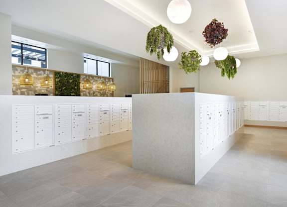 A white reception desk with a white wall behind it.