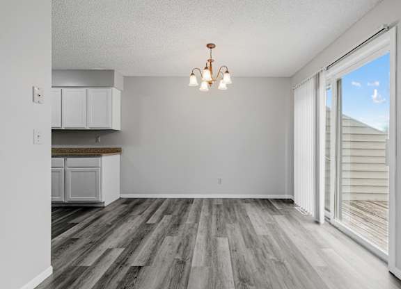 an empty living room with a sliding glass door to a kitchen
