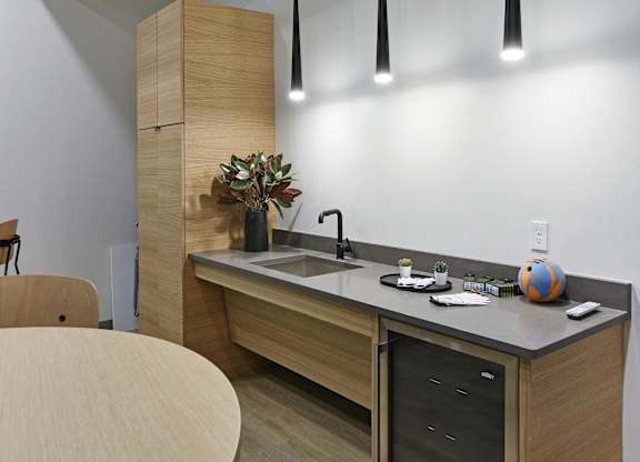 A modern kitchen with a wooden island and pendant lights.