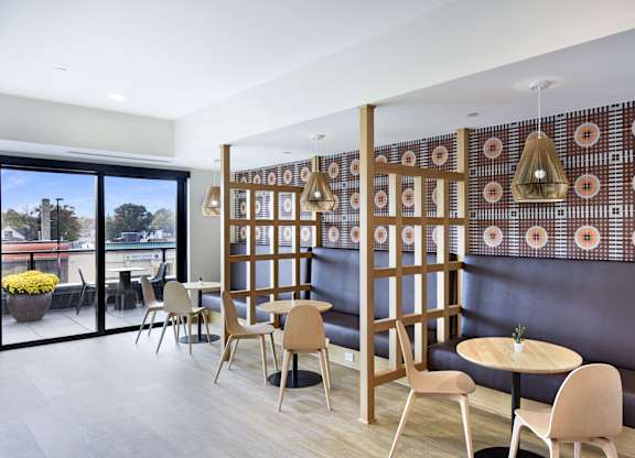 A room with a table and chairs and a wall with a pattern on it.