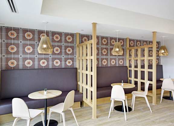 A restaurant with a patterned wallpaper and wooden partition.