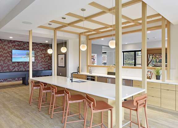A kitchen with a long white table and chairs.
