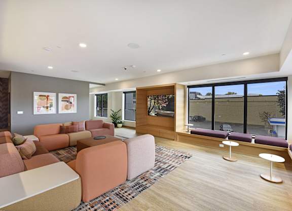 A modern living room with a large window and a wooden floor.