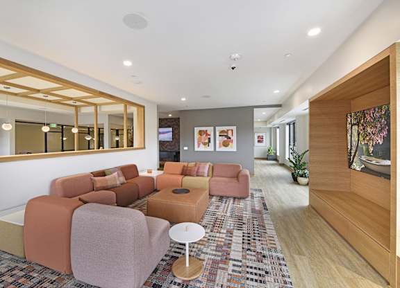 A living room with a large mirror and a rug.