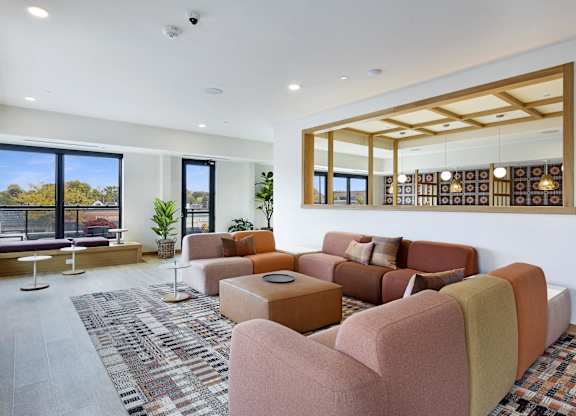 A living room with a large window and a view of trees outside.