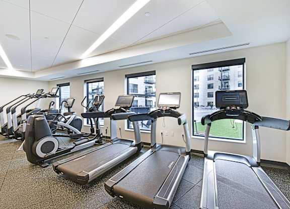 A gym with treadmills and elliptical machines.