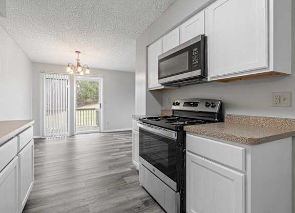 the kitchen of our studio apartment atrium with white cabinets and black appliances
